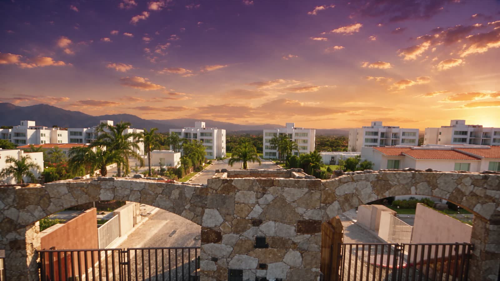 Vista aérea al atardecer de un desarrollo CCIDE en Morelos, con su acceso de piedra y palmeras